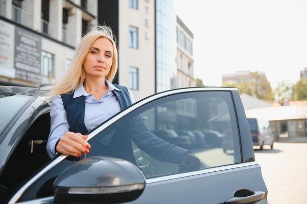 自動車の近くに立っている素敵なビジネスウーマン