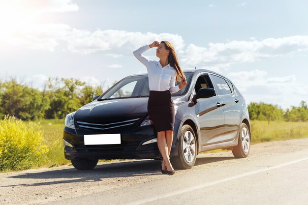 Nice businesswoman standing near her car