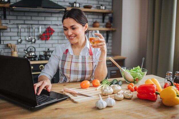 Nice cheerful woman sit at table in kitchen