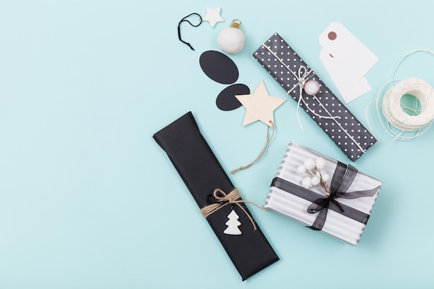 Nice Christmas gifts packed in black and striped paper and decorated with stars on blue background