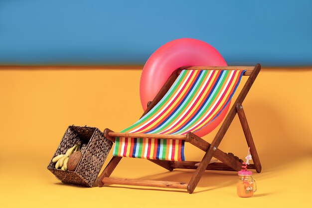 Nice deck chair at improvised artificial beach, complete with inflatable circle and box of tropical fruits