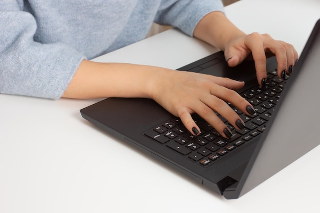 Nice European girl at home sitting at a laptop working shopping