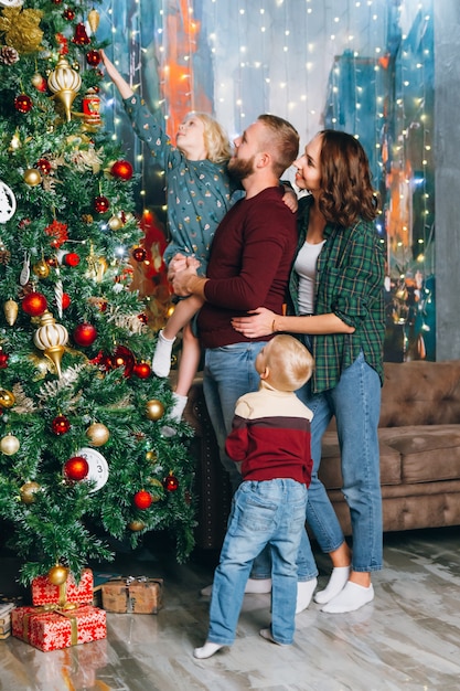 멋진 가족이 크리스마스 트리를 장식하고 있습니다.