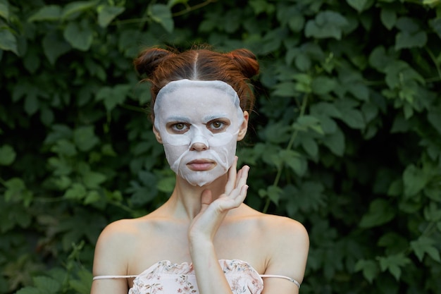 Nice girl cosmetic mask spaghetti strap shirt model bare shoulders green leaves in the background