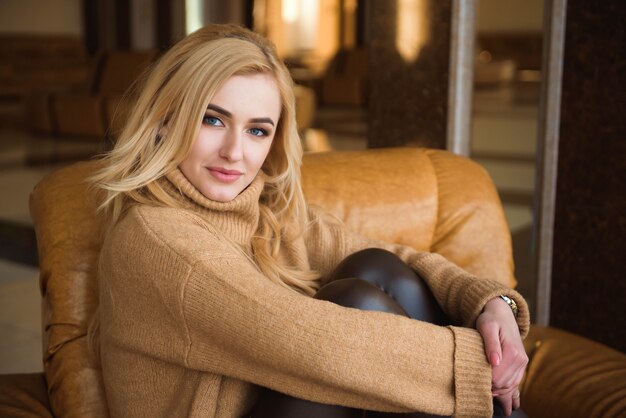 Photo nice girl is resting on the big armchair