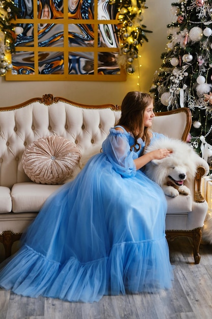 Nice girl in a light blue dress with white Samoyed dog