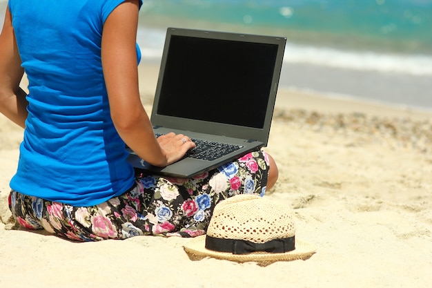 Nice girl with laptop by the sea