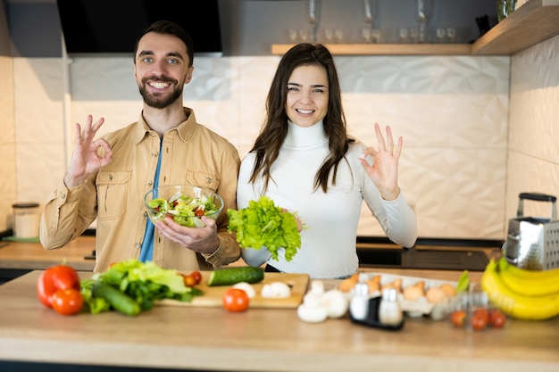 Nice guy and sweet girl with pretty smile are showing that they prefer vegetables to meat to save animals