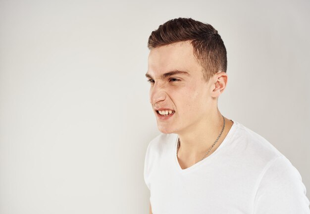 Nice guy in a white t-shirt on a light background cropped view portrait close-up