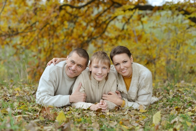 Nice happy family lying in autumn park