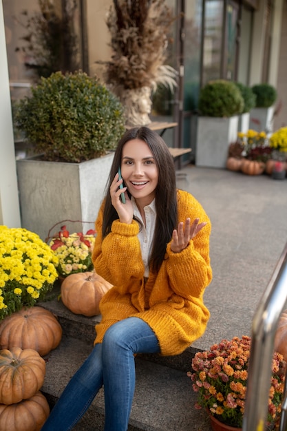 Nice joyful woman having a pleasant phone conversation while calling to her friend