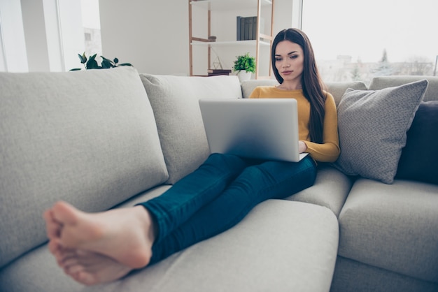 Nice lovely woman posing on the couch writing