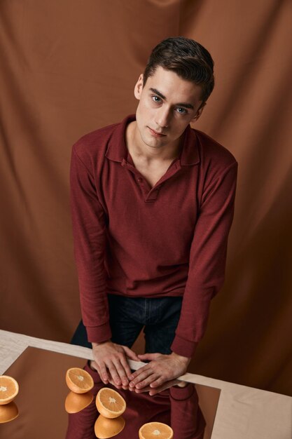 Nice man in a red shirt with oranges on the studio mirror