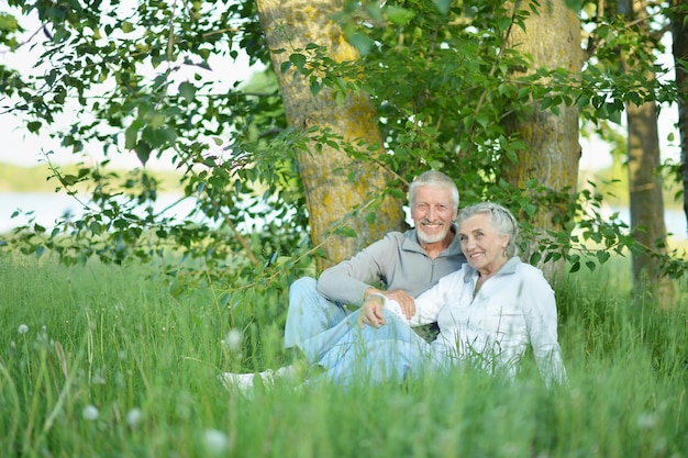 緑の草の上に座っている素敵な成熟したカップル