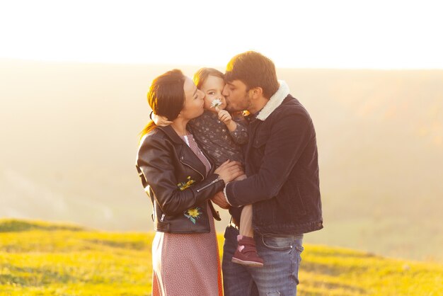 Una bella foto di una giovane famiglia in piedi in un campo divertendosi