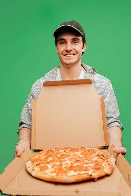 Хороший доставщик пиццы открывает коробку с пиццей