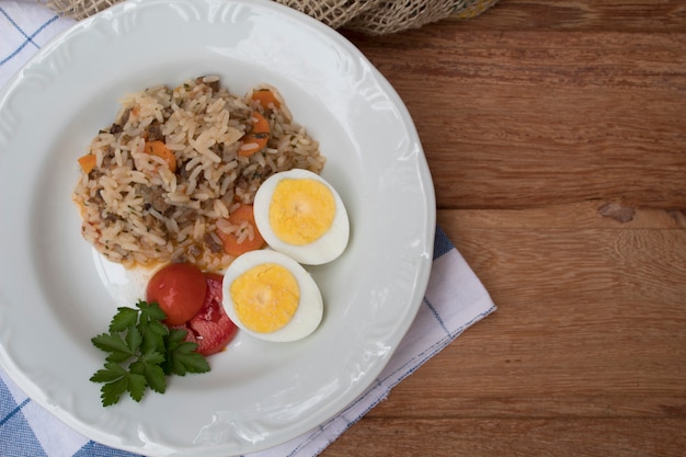 A nice plate of rice, boiled eggs and tomatoes in top view