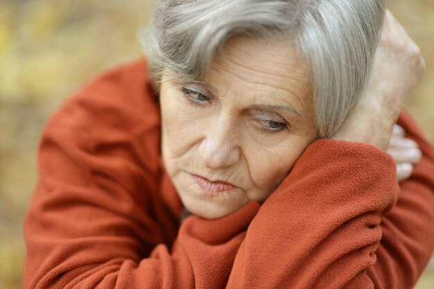 Photo nice sad old woman on the autumn background