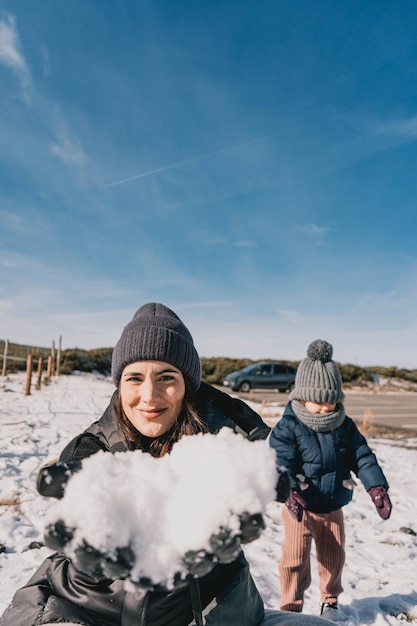 写真 晴れた日に雪を楽しんでいる母と娘の素敵な場面