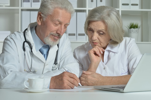 Nice senior Doctors   with laptop in office