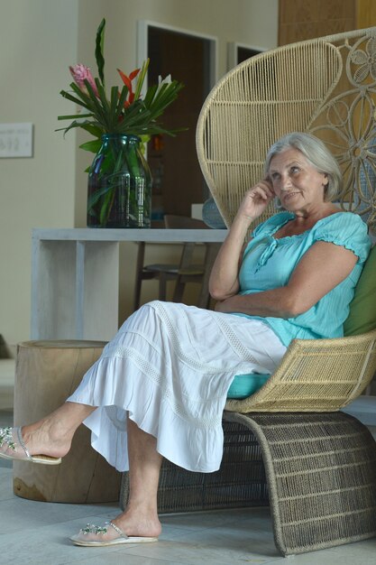 Nice senior woman resting in hotel hall