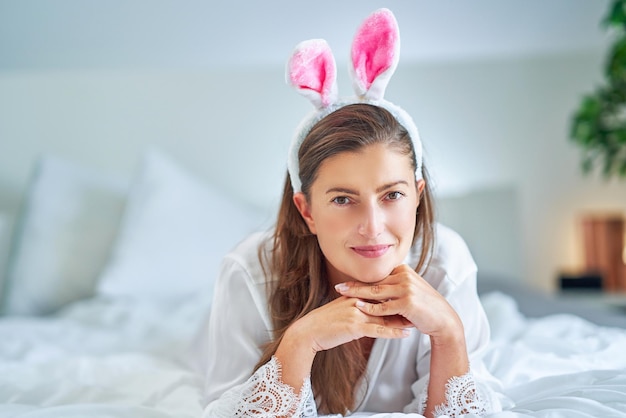 Nice and sexy brunette on bed with bunny ears