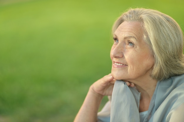 Nice smiling old woman on green background