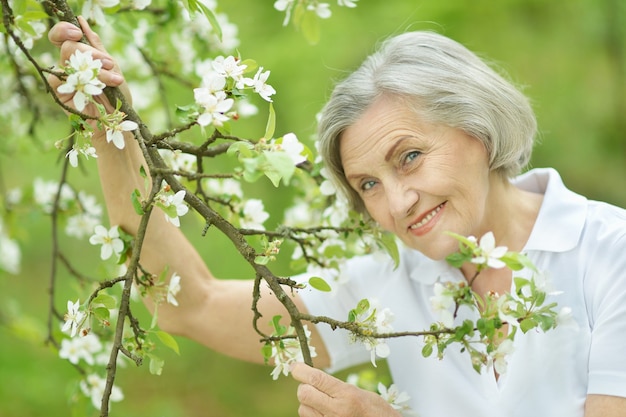 Симпатичная улыбающаяся старуха на фоне зеленых листьев