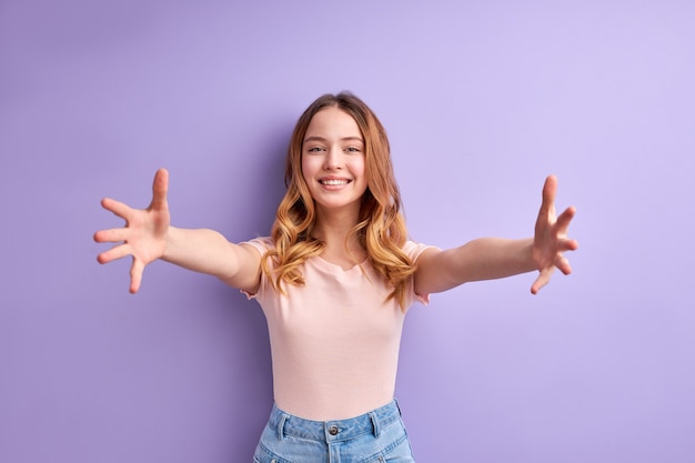 Nice Teen Girl Spreading Arms, Going To Hug, Smiling, In Casual T-shirt, Portrait Of Young Friendly Pleasant Teenager Girl With Wavy Blonde Hair