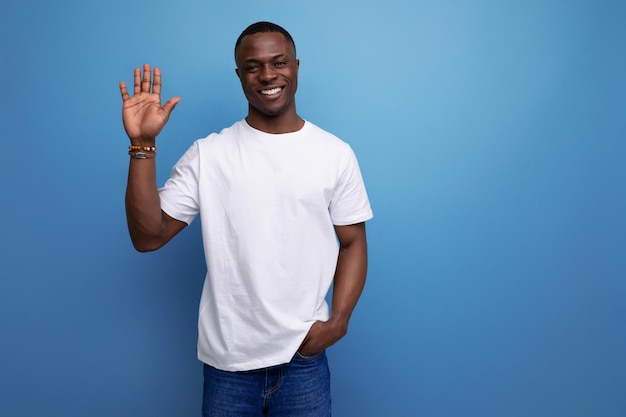 Nice young african guy in white tshirt waving his hand