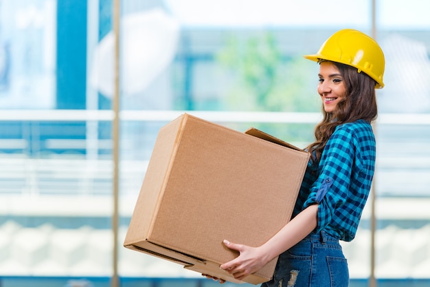 Nice young woman carrying box