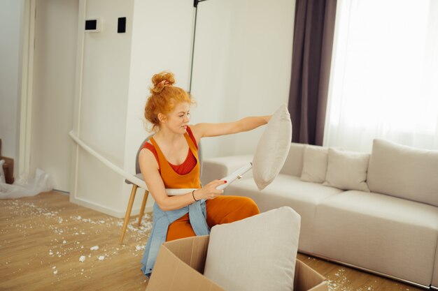 Photo nice young woman looking at the cushion