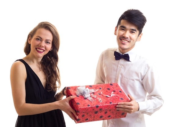 Nice young woman with blond hair in black dress presenting young handsome man with dark hair