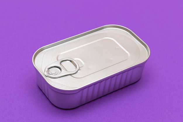 Niet geopend blik met een lege rand op een violette achtergrond