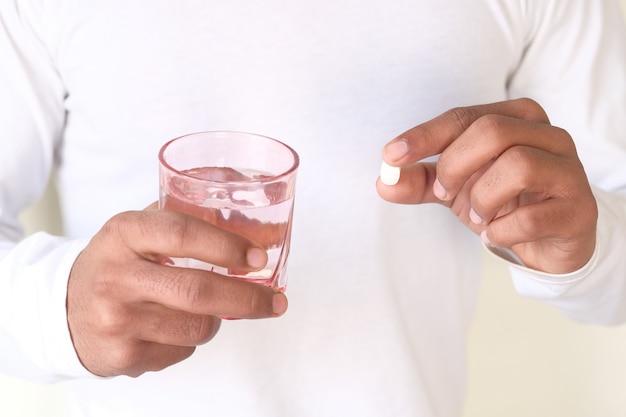 Niet-herkende man in wit overhemd met medicijnen.