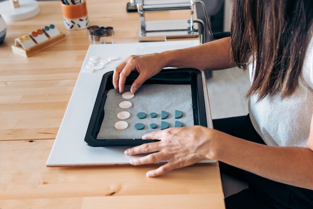 Niet-herkende vrouw die vanuit huis werkt en prachtige handgemaakte sieraden maakt.