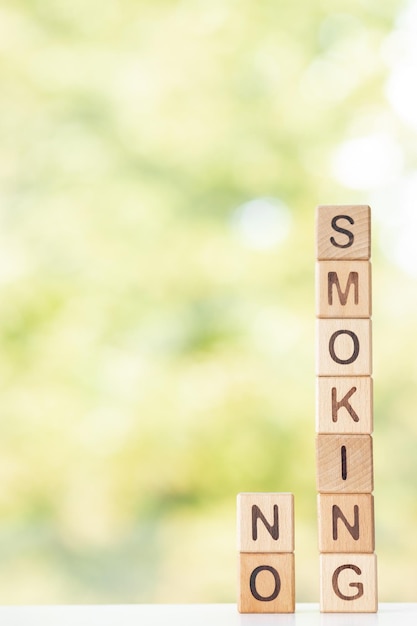 Niet roken is geschreven op houten kubussen op een groene zomerachtergrond Close-up van houten elementen