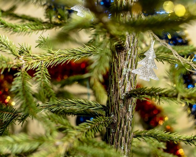 Foto niet verlichte kerstslinger hangend aan een levende kerstboom tussen klatergoud