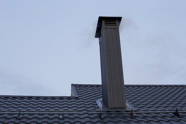 Nieuw dak en pijp van metaal en zwart. Moderne materialen voor het bouwen van een huis