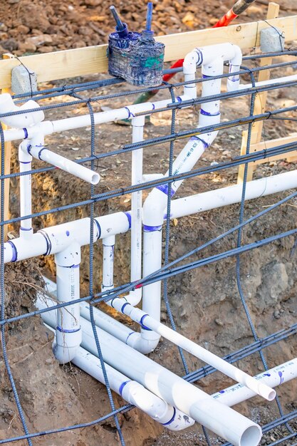 Nieuw geïnstalleerde PVC- loodgietersleidingen en staalstavenconfiguratie op de bouwplaats