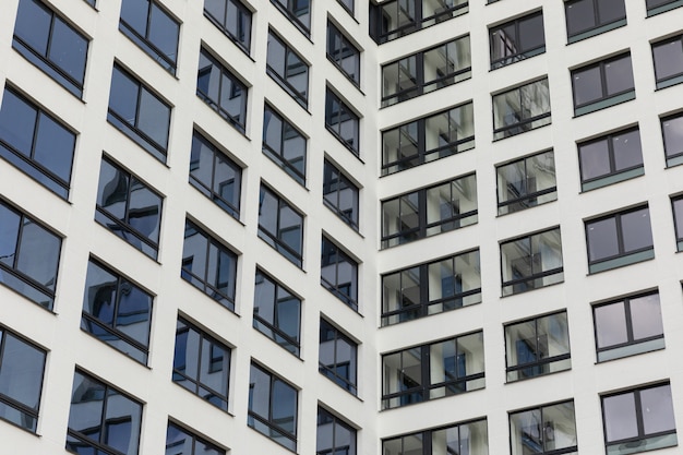 Nieuw onroerend goed te koop, appartement gevel met brede zwarte ramen en lucht reflectie.