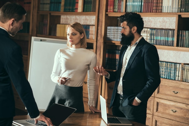 Nieuw technologieconcept. Vrouw en mannen gebruiken nieuwe technologie voor zakelijke communicatie. Nieuwe technologie en innovatie. Gebruik van computers en nieuwe technologie in de bibliotheek