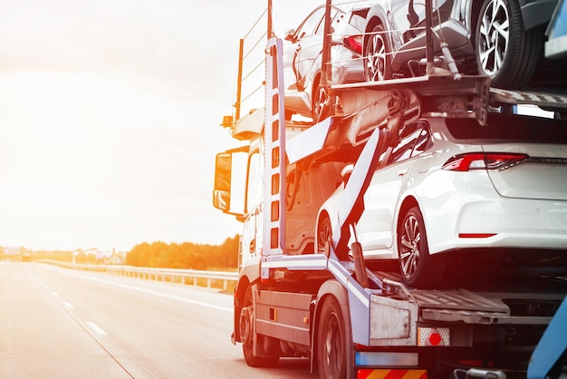 Foto nieuwe auto's op een hydraulische aanhangwagen klaar voor levering en verkoop een auto-transportwagen vervoert veel auto's met een modulaire rampe op twee niveaus snelle en efficiënte verzenddienst voor klanten uit de auto-industrie