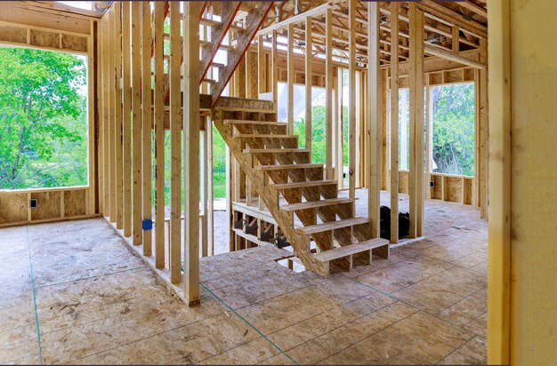 Nieuwe constructie van een huis met een balkconstructie omlijst de grond tegen een blauwe hemel