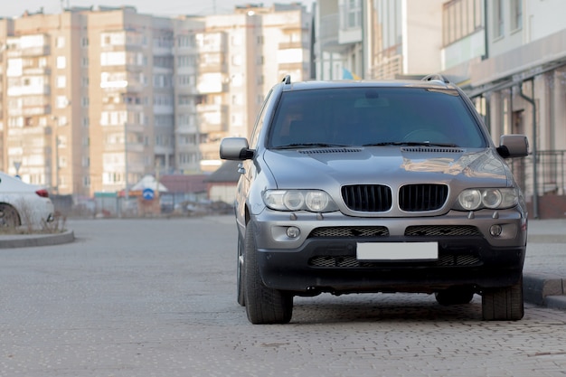 Nieuwe dure grijze auto geparkeerd op verharde parkeerplaats aan de voorkant. Transport- en parkeerconcept