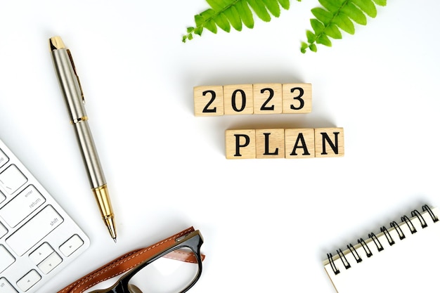 Nieuwe jaarplan. plannen voor 2023. toetsenbord, notitieboekje en pen, 2023 plan-woord is geschreven op houtblok,