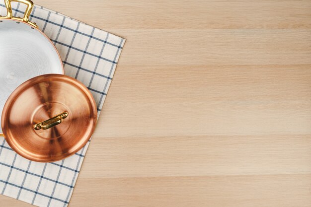 Nieuwe koperen kookpot op houten tafelaanzicht van bovenaf