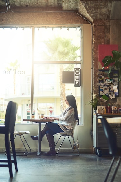 Nieuwe omgevingen brengen nieuwe inspiraties shot van een jonge vrouw die een laptop gebruikt in een café