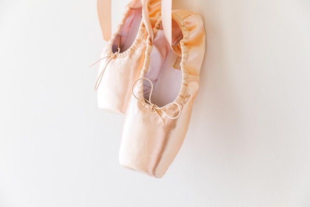 Nieuwe pastel beige balletschoenen met satijnen lint geïsoleerd op witte achtergrond ballerina klassieke poi...