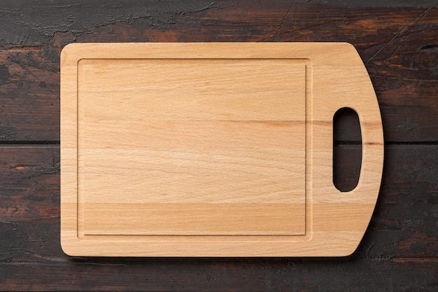 Nieuwe rechthoekige bamboe houten snijplank op houten tafel. Bovenaanzicht. Bespotten voor voedselproject.